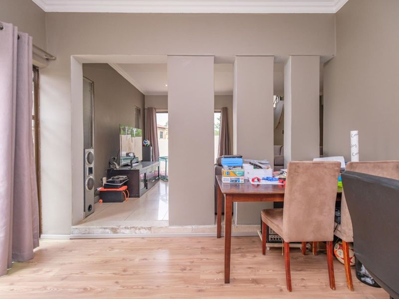 Living area featuring a partition wall separating two spaces, with a mix of laminate and tiled flooring and access to an outdoor area.