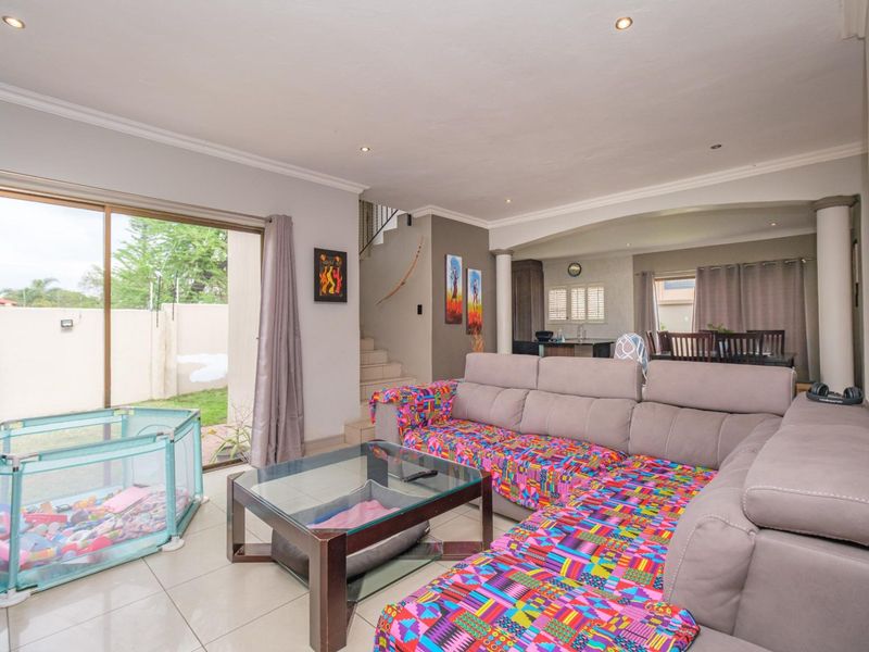 Spacious open-plan living area featuring tiled floors, recessed lighting, and a sliding door providing direct access to the outdoor garden space.