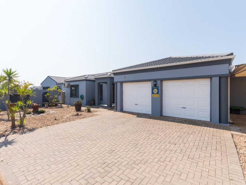 Front view of a modern house featuring a double garage, paved driveway, and well-maintained exterior finishes.