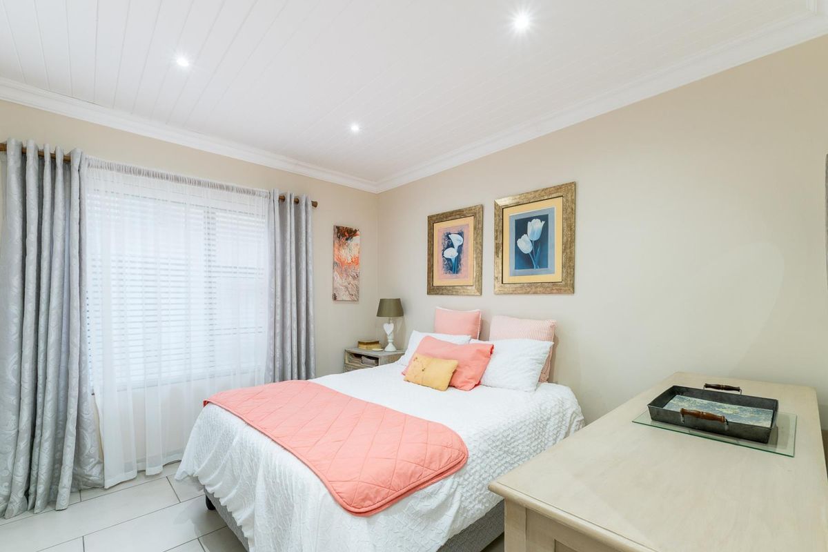 A well-maintained bedroom featuring tiled flooring, a tongue and groove ceiling with recessed lighting, and crown molding.