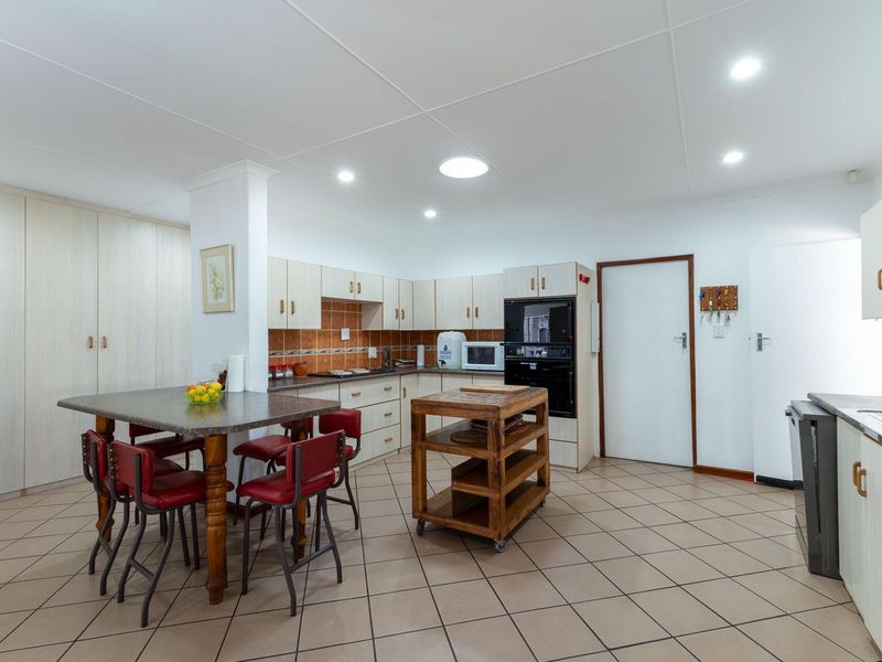 Spacious kitchen featuring built-in cabinetry, tiled flooring, integrated oven and microwave, and a functional layout with ample storage and workspace.