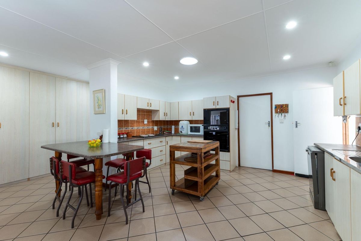 Spacious kitchen featuring built-in cabinetry, tiled flooring, integrated oven and microwave, and a functional layout with ample storage and workspace.
