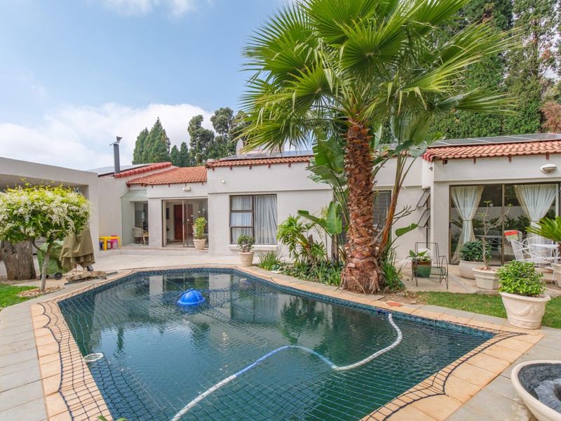A well-maintained outdoor pool area featuring a safety net, tiled surround, and direct access to the home via sliding glass doors.