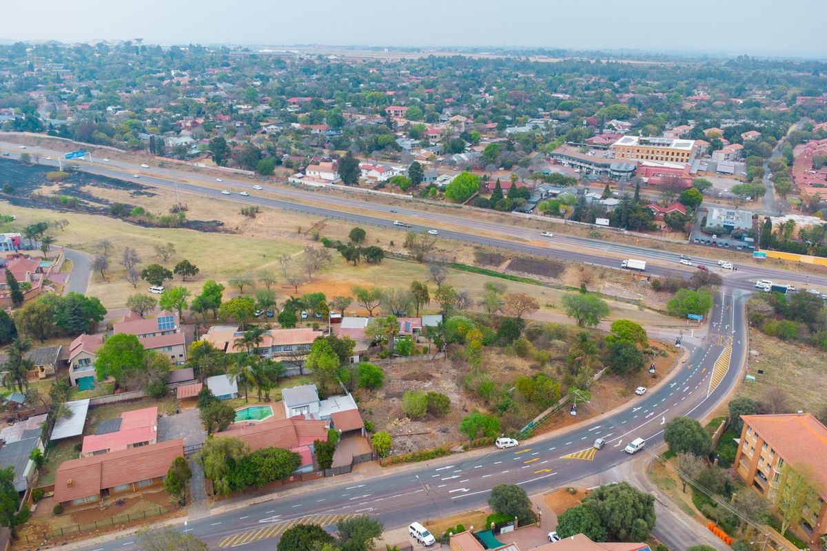 Aerial view of a vacant residential plot situated in a developed suburban area with convenient access to major road networks.