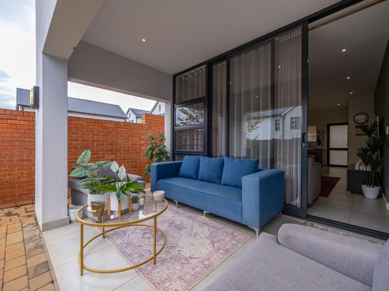 A covered patio area featuring tiled flooring, recessed lighting, and large sliding glass doors providing seamless access to the interior living space.