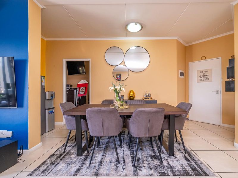 A dining area featuring tiled flooring and neutral wall tones, providing a functional space for meals and gatherings.