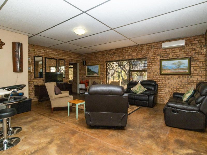 Spacious living area featuring exposed brick walls, polished concrete flooring, and a split-system air conditioner, offering a rustic farm-style aesthetic.
