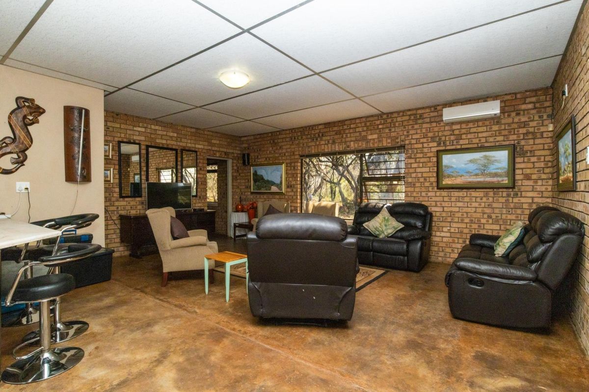 Spacious living area featuring exposed brick walls, polished concrete flooring, and a split-system air conditioner, offering a rustic farm-style aesthetic.