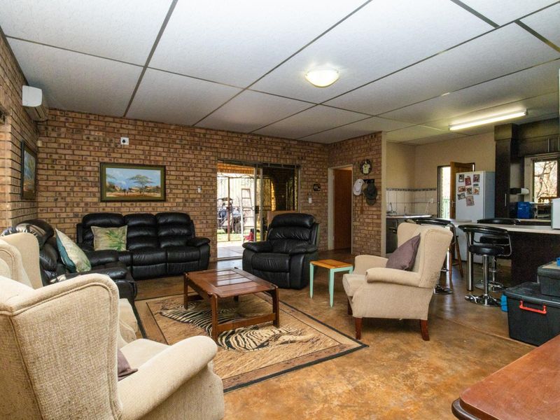 Open-plan living and kitchen area featuring exposed brick walls, concrete flooring, and a functional kitchen island with integrated cabinetry.