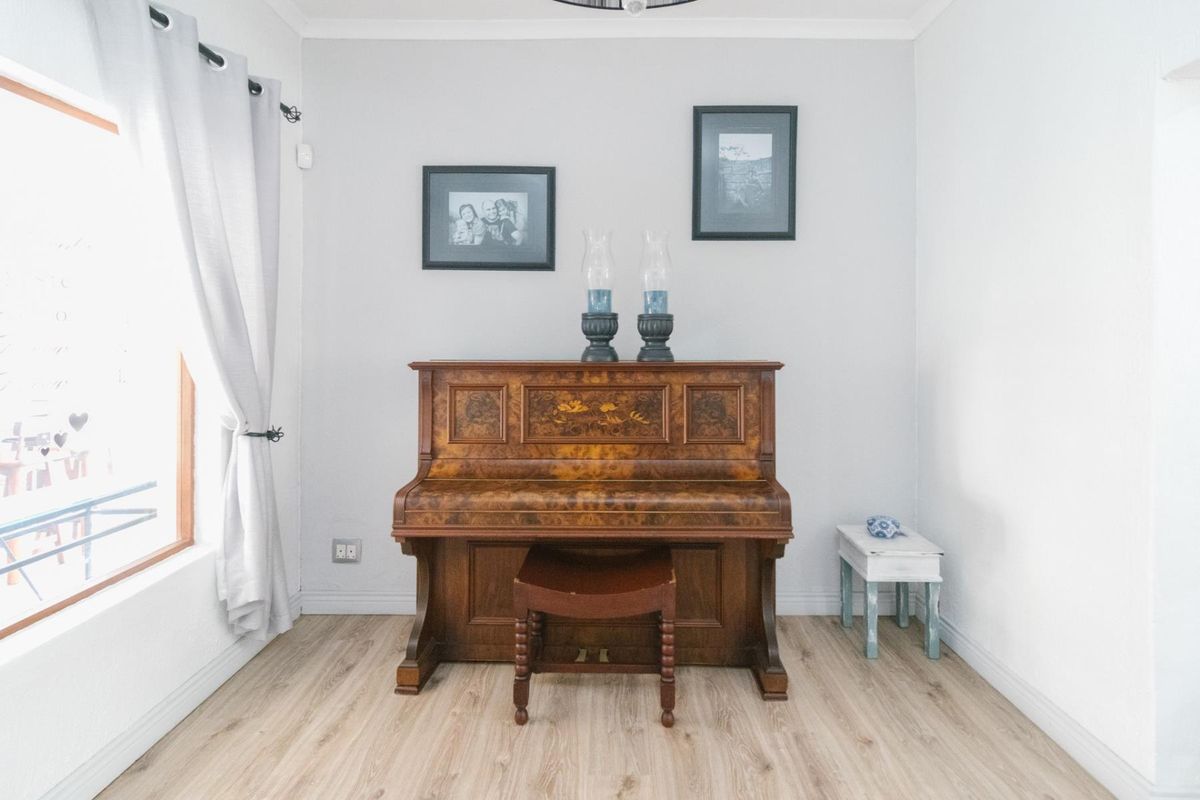 A bright living area featuring light-toned laminate flooring, neutral walls, and coving detail, providing a clean and versatile space.