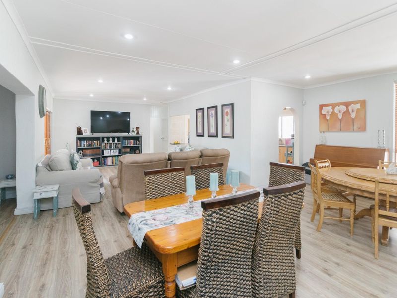 Spacious open-plan living and dining area featuring modern laminate flooring and recessed downlighting, creating a bright and functional family space.