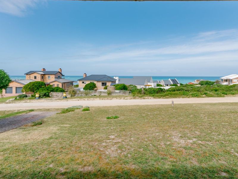 A scenic elevated view overlooking a coastal neighbourhood with ocean vistas in the distance.