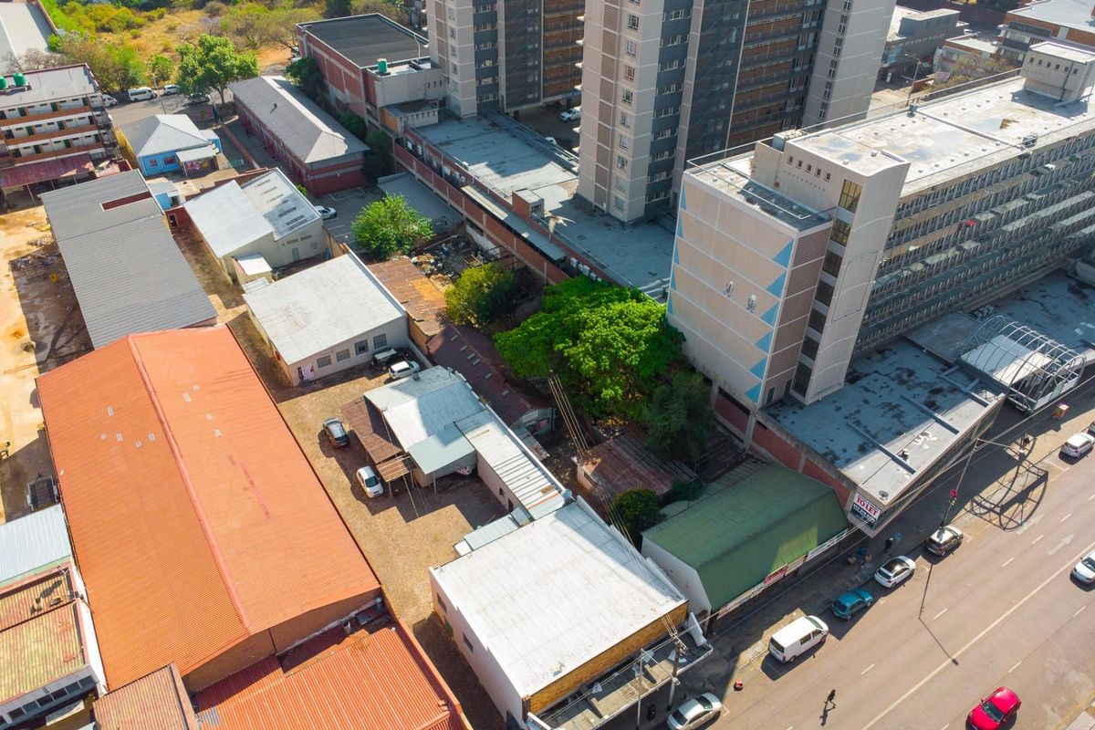 Aerial view of a commercial property complex featuring multiple buildings with corrugated metal roofing and paved access areas in an urban setting.