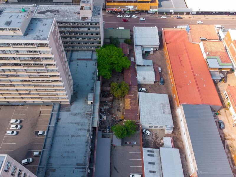 Aerial view of a commercial property complex featuring multiple buildings with corrugated metal roofing, paved parking areas, and a central yard space.