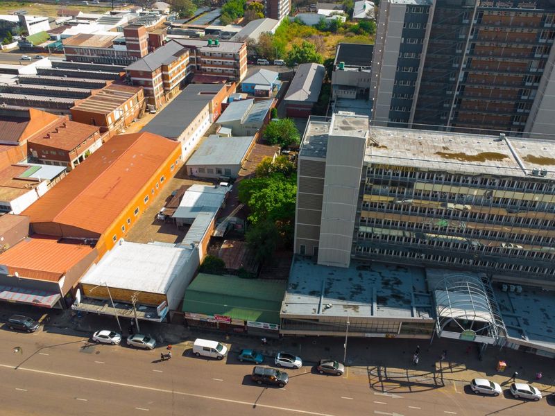 Aerial view of a commercial retail block featuring multiple buildings, flat roofs, and street-level access in an urban environment.