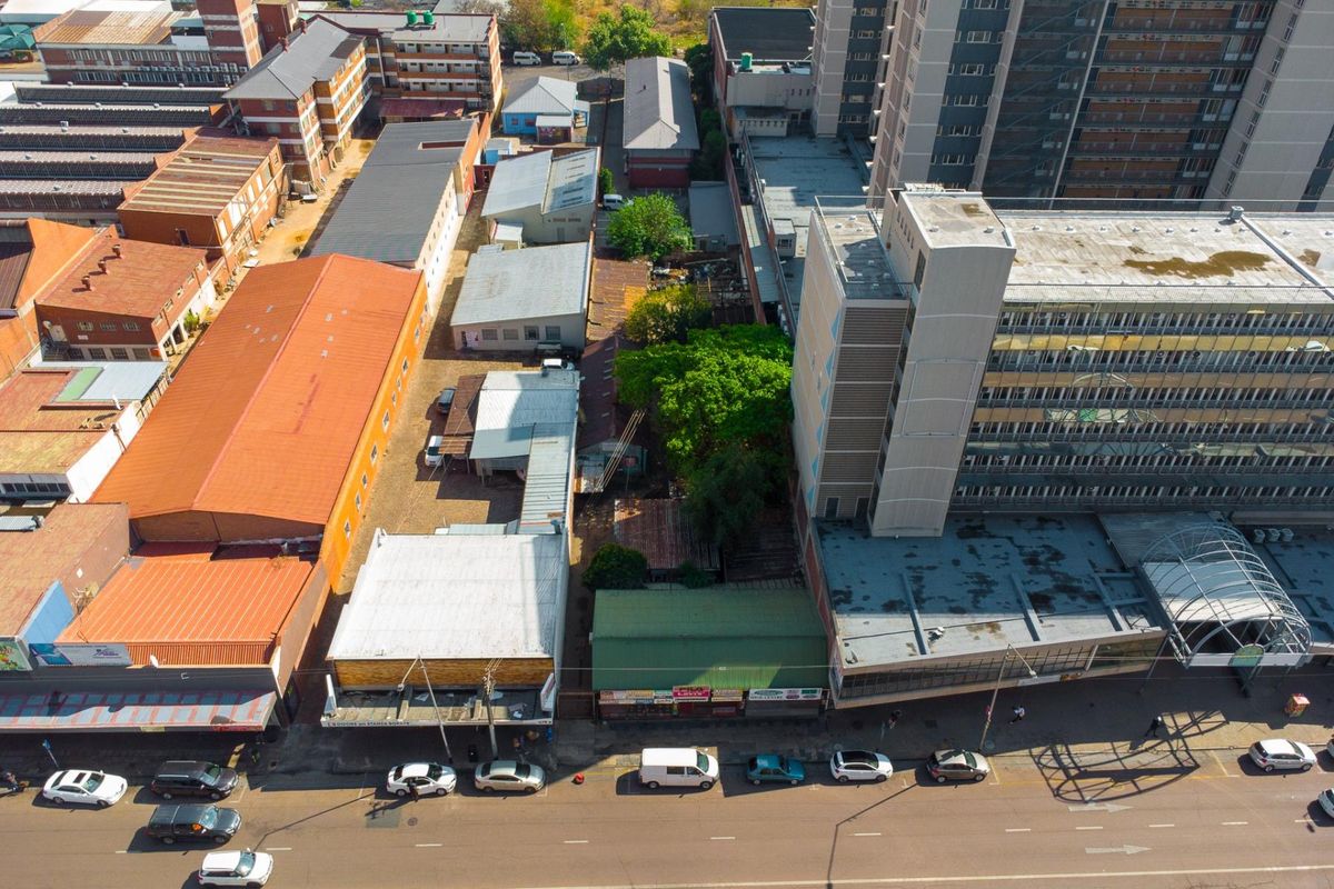 Aerial view of a commercial property block featuring multiple buildings with metal roofing, street frontage, and rear parking access in an urban setting.