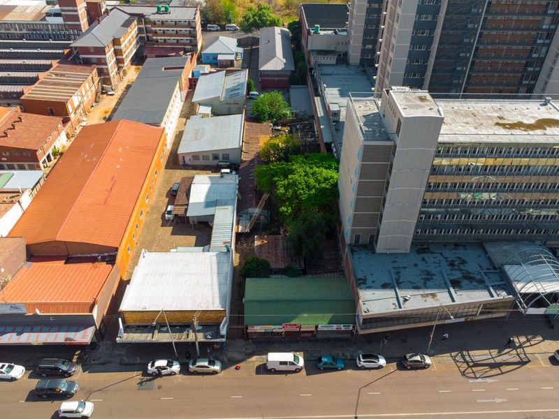 Aerial view of a commercial property block featuring multiple buildings with metal roofing, street frontage, and rear parking access in an urban setting.
