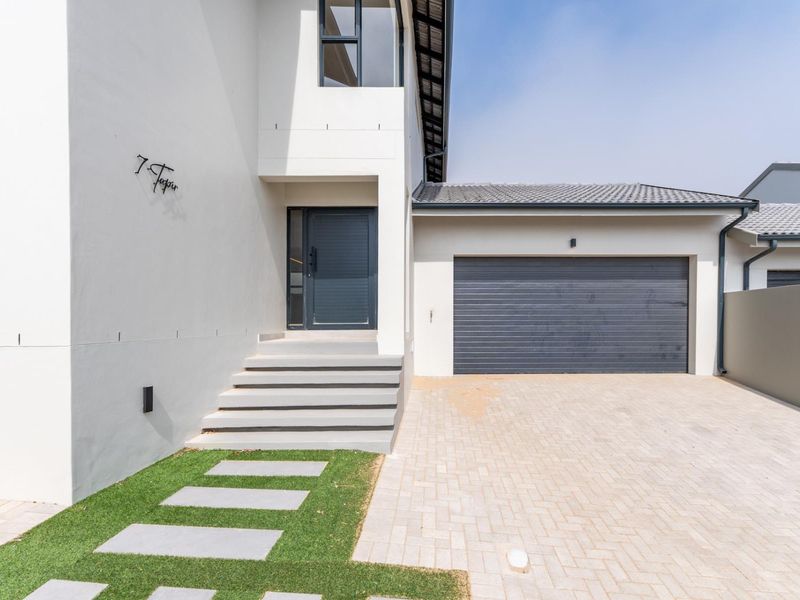 Modern front elevation featuring a paved driveway, single garage, and a clean, contemporary entrance with concrete steps and minimalist exterior lighting.