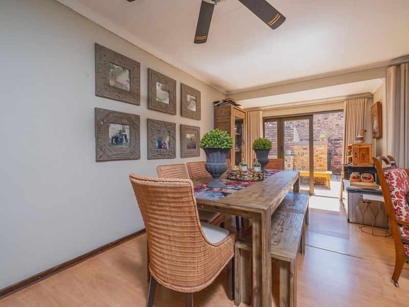 Dining room featuring laminate flooring, a ceiling fan, and sliding glass doors providing access to the rear patio area.