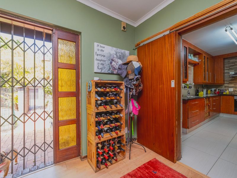 Entryway featuring a security gate, sliding wooden door, and tiled flooring, providing direct access to the adjacent kitchen area.