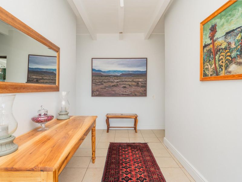 A bright and well-maintained hallway featuring tiled flooring and exposed ceiling beams, creating a clean and welcoming entrance space.