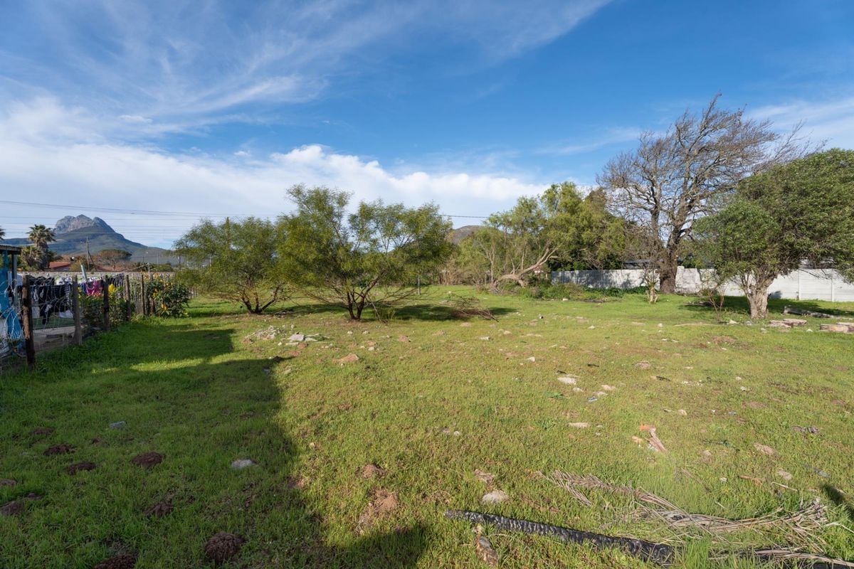 A spacious, level residential plot featuring established trees and perimeter fencing, offering a blank canvas for future development.