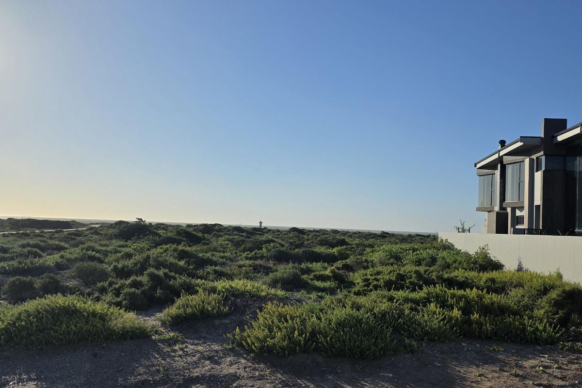 A scenic view of the natural coastal landscape and vegetation adjacent to a modern residential property.