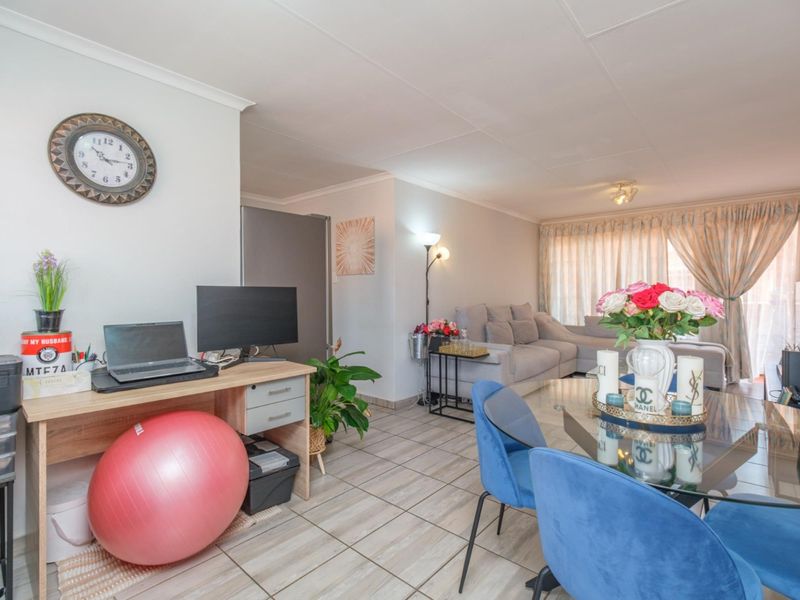 An open-plan living and dining area featuring tiled flooring and coved ceilings, providing a versatile space for relaxation and meals.
