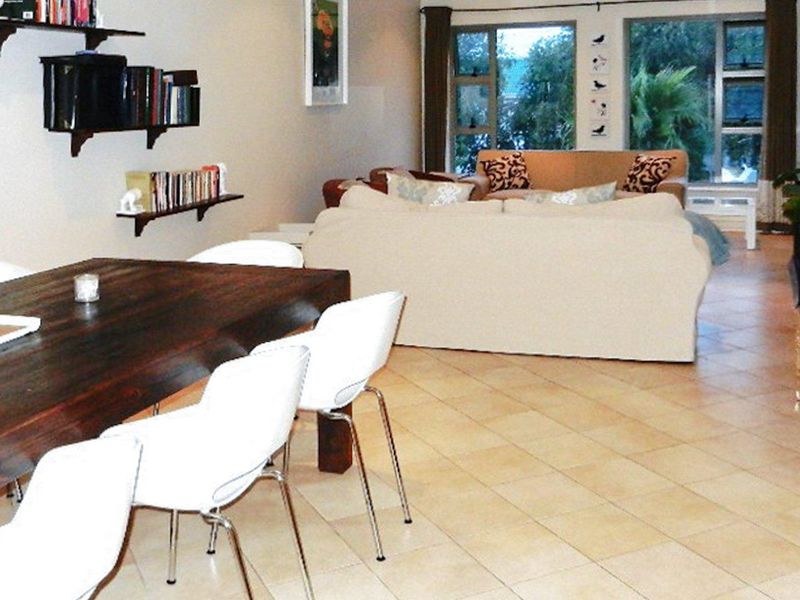 Open plan living and dining area featuring tiled flooring and large windows providing natural light.