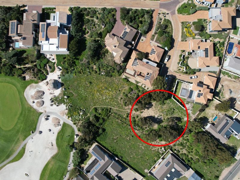 Aerial view of a vacant residential plot situated within a developed estate, adjacent to a golf course.