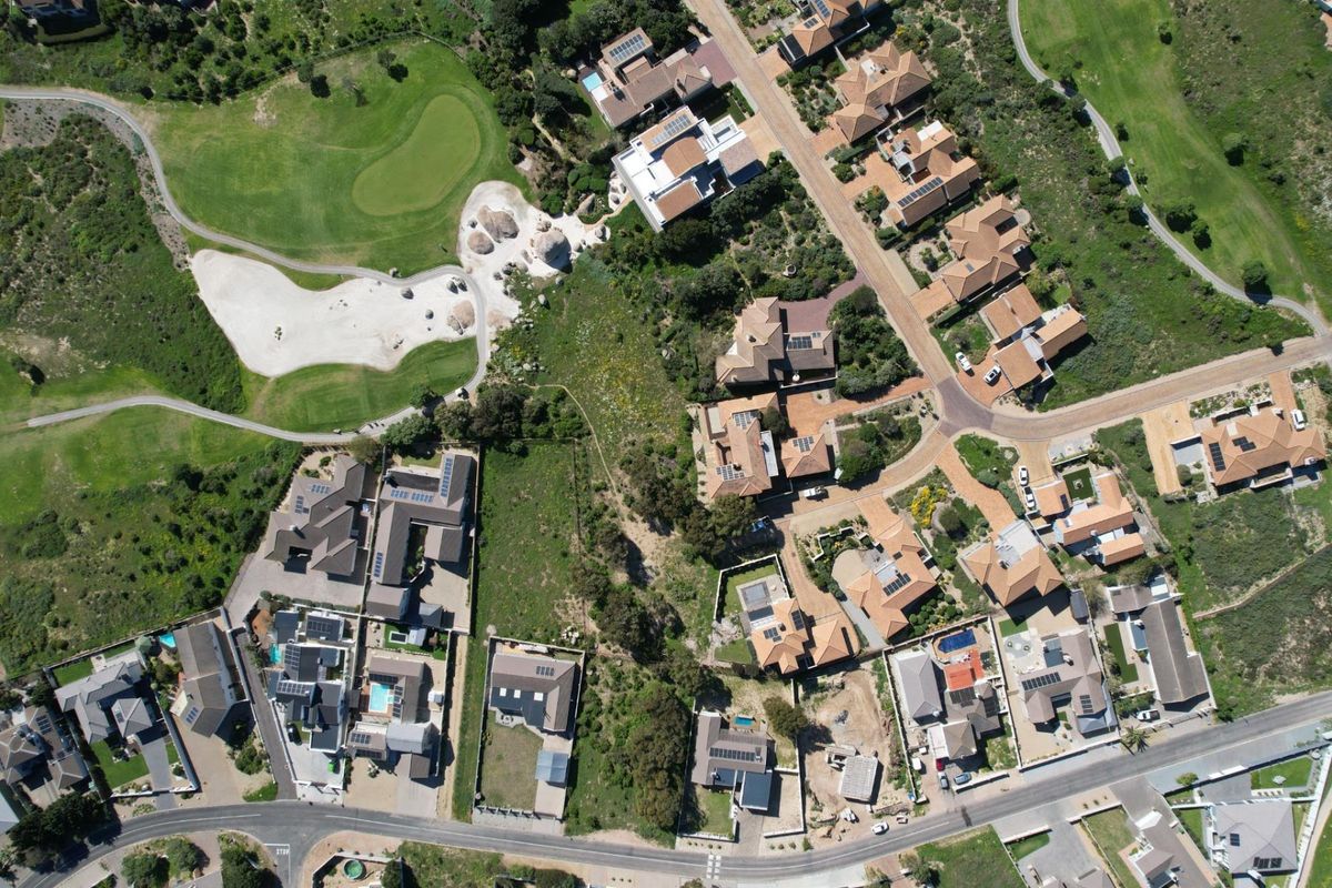 An aerial view of a residential estate featuring established homes, paved road networks, and adjacent golf course fairways.