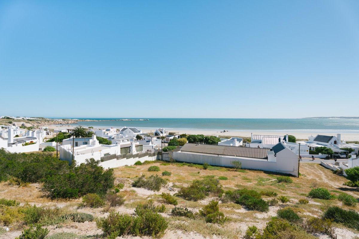 A scenic elevated view overlooking a coastal residential area with direct proximity to the beach and ocean.