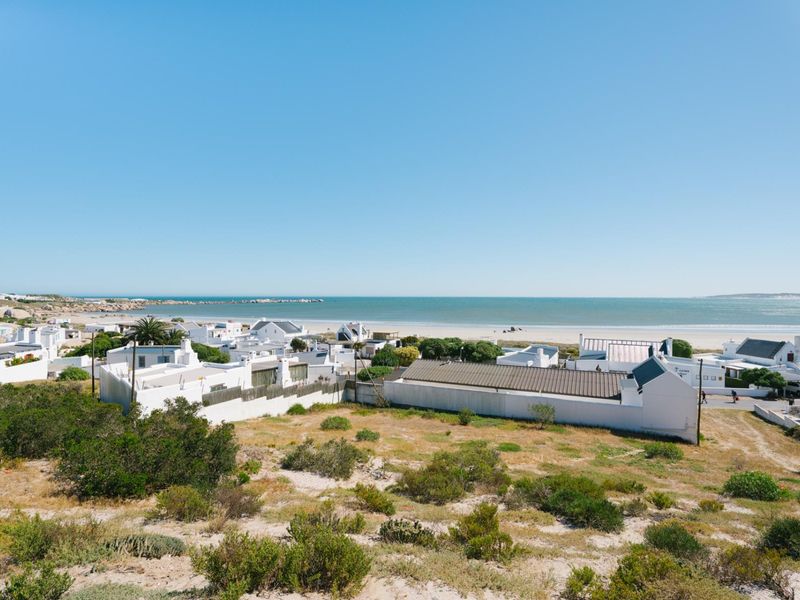 A scenic elevated view overlooking a coastal residential area with direct proximity to the beach and ocean.