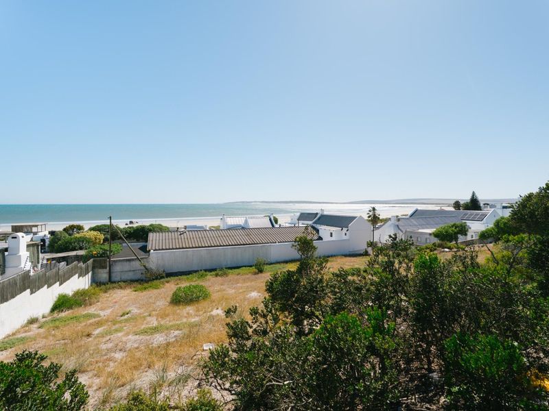 A scenic elevated view overlooking the coastal landscape and ocean, showcasing the surrounding residential area and natural terrain.