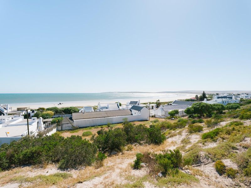 Elevated view overlooking a coastal residential area with direct beach access and scenic ocean vistas.