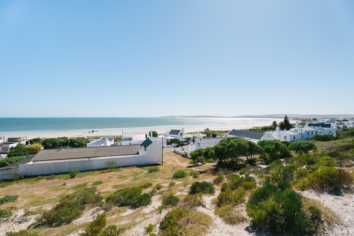 A scenic elevated view overlooking a coastal residential area with direct proximity to the beach and ocean.