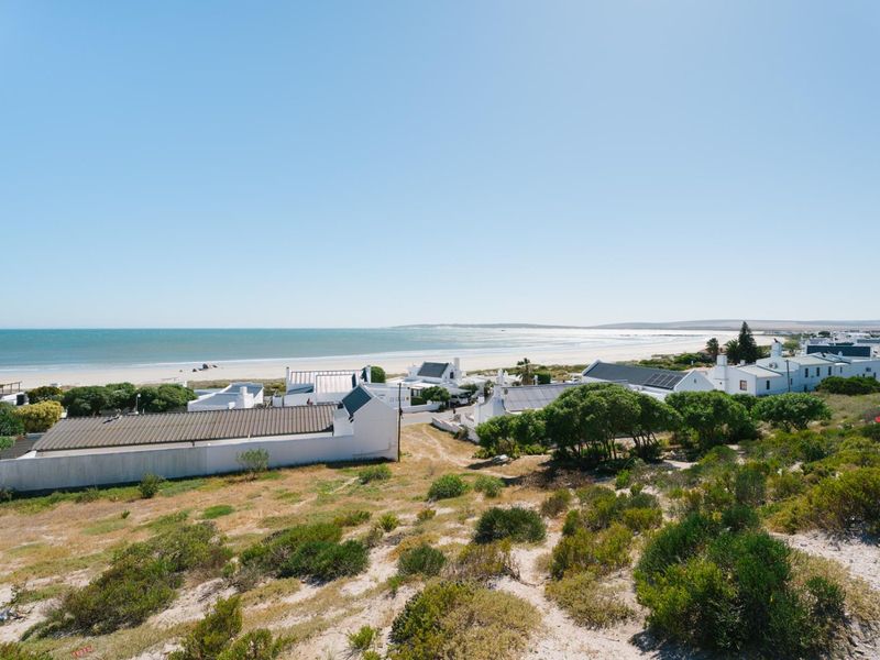 A scenic elevated view overlooking a coastal residential area with direct proximity to the beach and ocean.