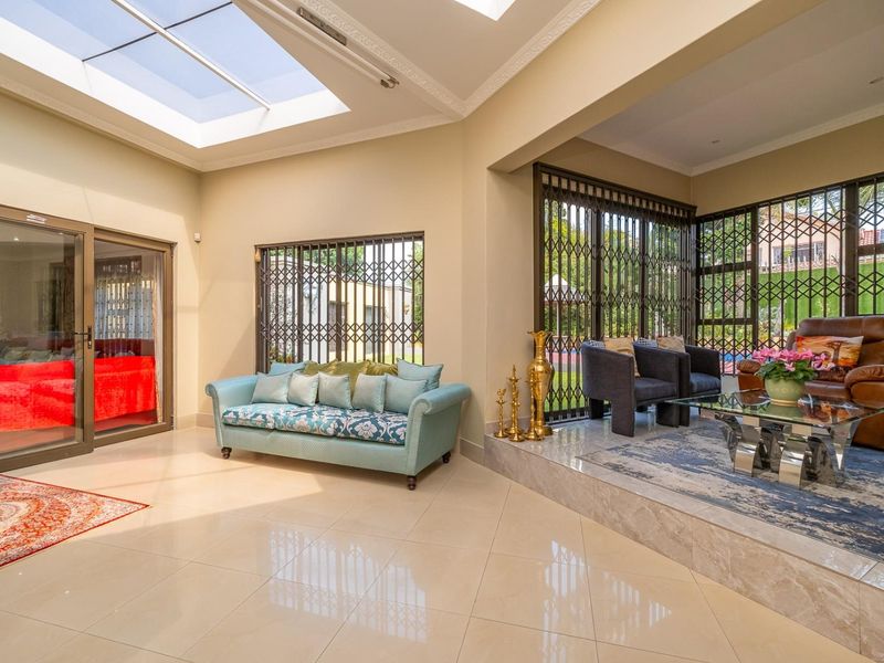 Spacious living area featuring large skylights, polished tile flooring, and a raised seating platform with secure access to the outdoor area.