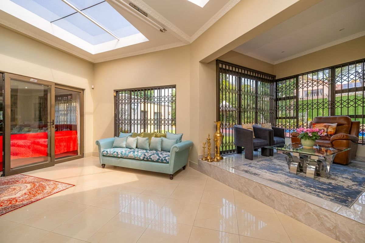 Spacious living area featuring large skylights, polished tile flooring, and a raised seating platform with secure access to the outdoor area.