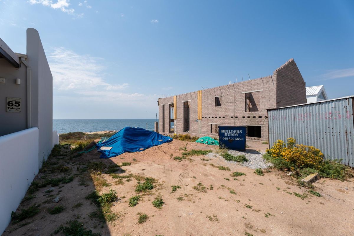 A view of a residential property under construction, featuring an exposed concrete block structure with ocean views.