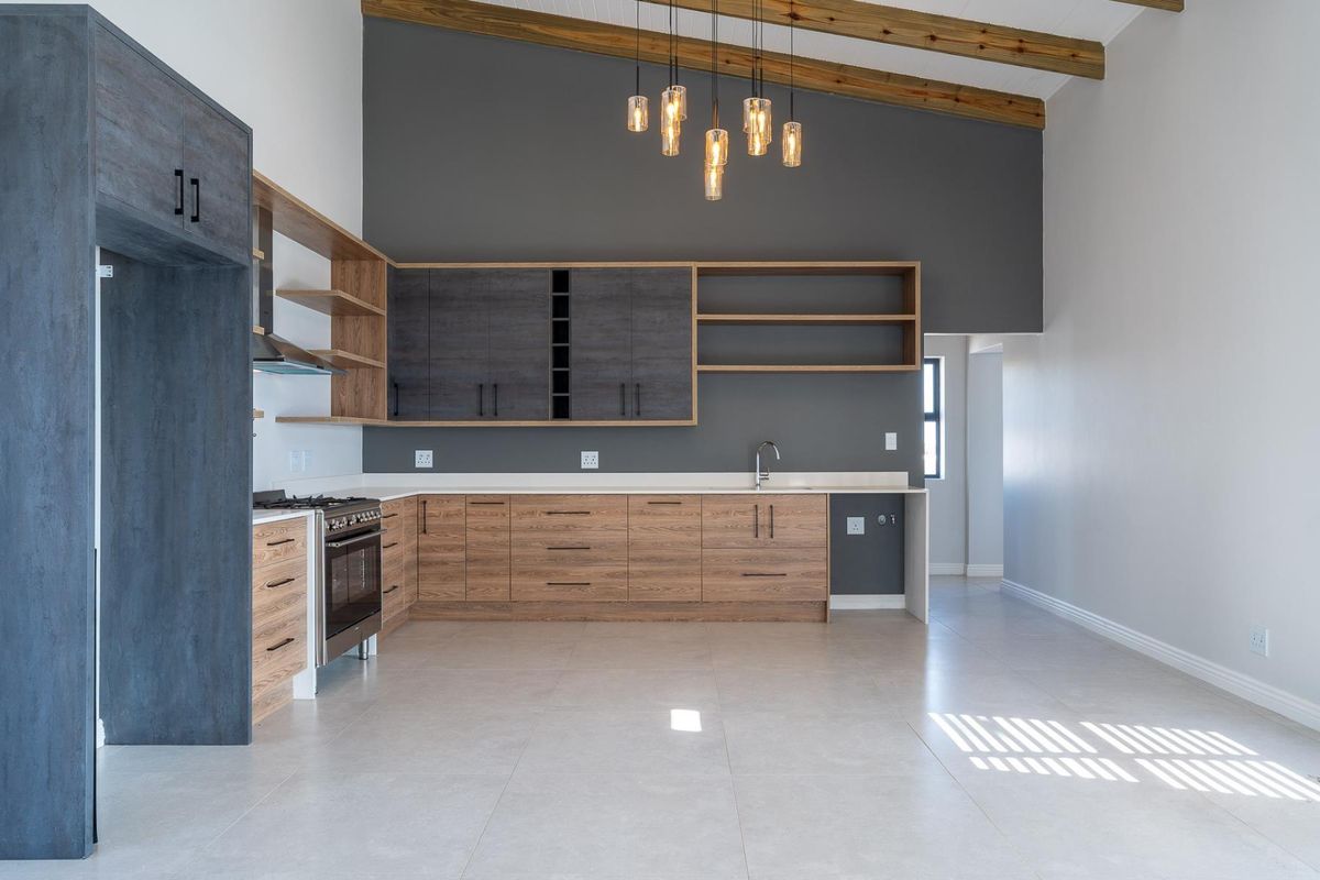 Modern kitchen featuring wood-grain and dark cabinetry, gas stove, extractor fan, and exposed timber beams under a high vaulted ceiling.