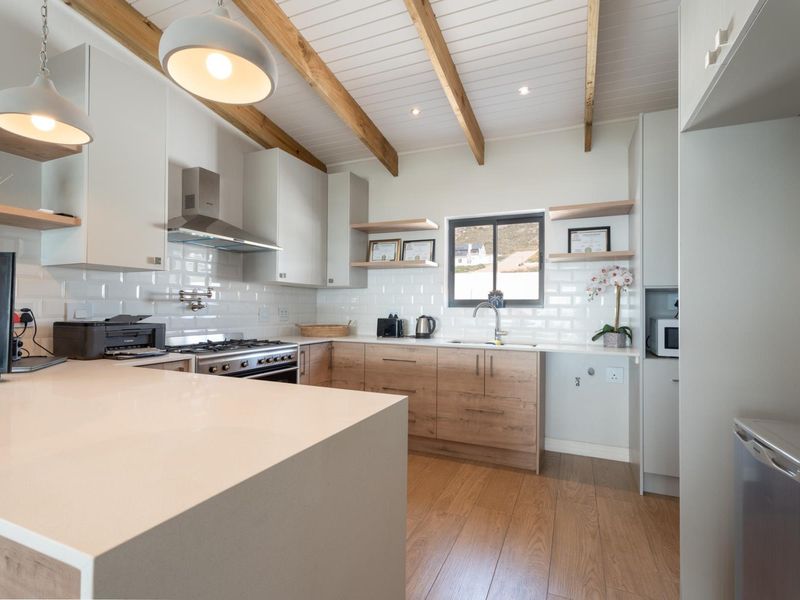 Modern kitchen featuring timber cabinetry, quartz countertops, subway tile backsplash, and exposed timber ceiling beams, creating a bright and contemporary culinary space.