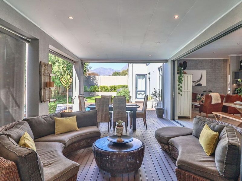 Spacious covered patio featuring timber decking, recessed lighting, and large sliding glass doors that seamlessly connect the indoor and outdoor living areas.