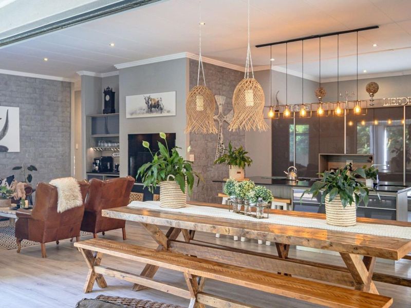 Spacious open-plan living and kitchen area featuring modern cabinetry, a large kitchen island, recessed lighting, and an attractive exposed brick feature wall.