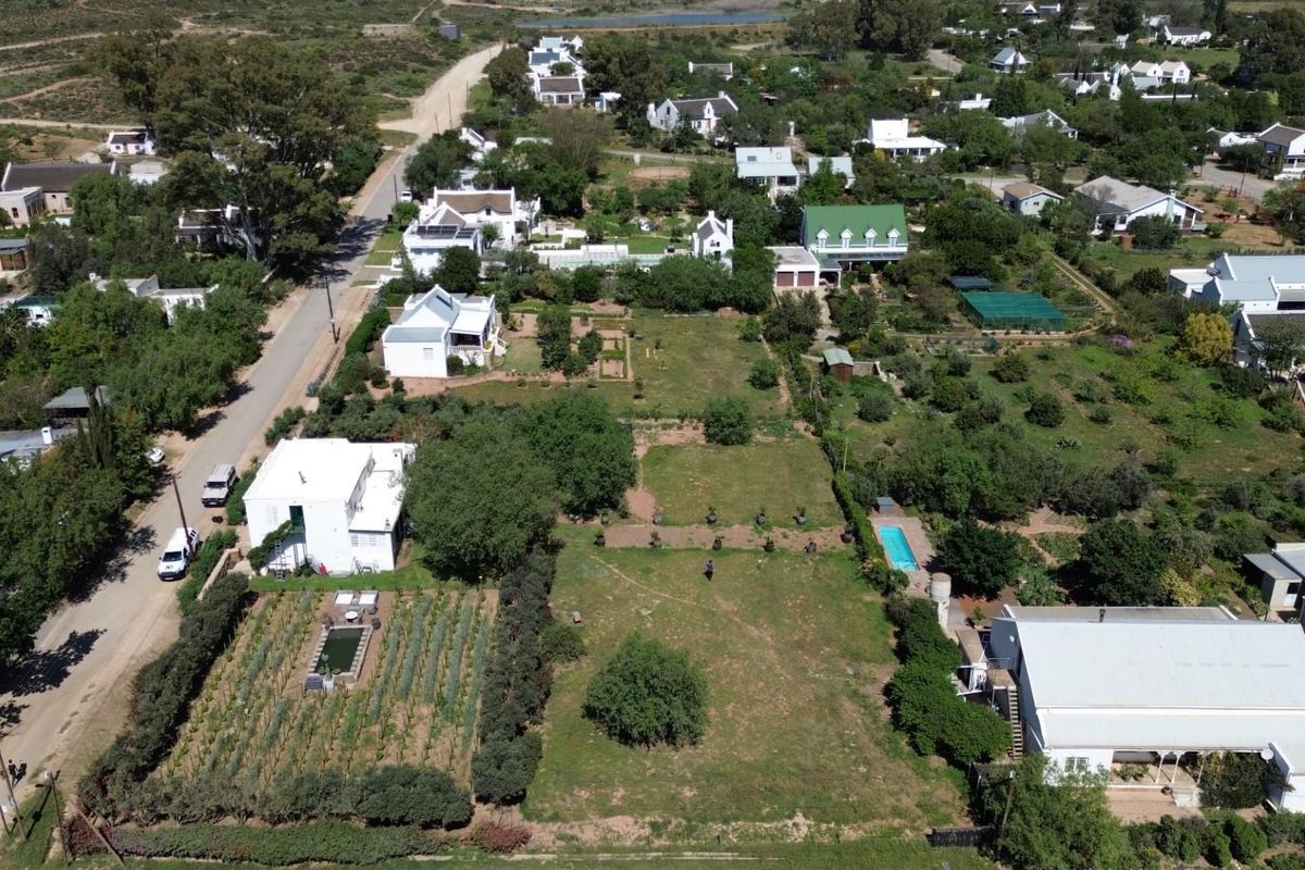 Aerial view of a residential property featuring a large garden, swimming pool, and established landscaping within a quiet neighborhood setting.