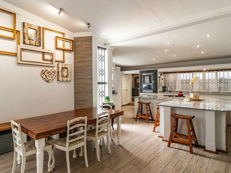 Spacious open-plan kitchen and dining area featuring a large stone-topped island, modern cabinetry, and recessed lighting throughout.