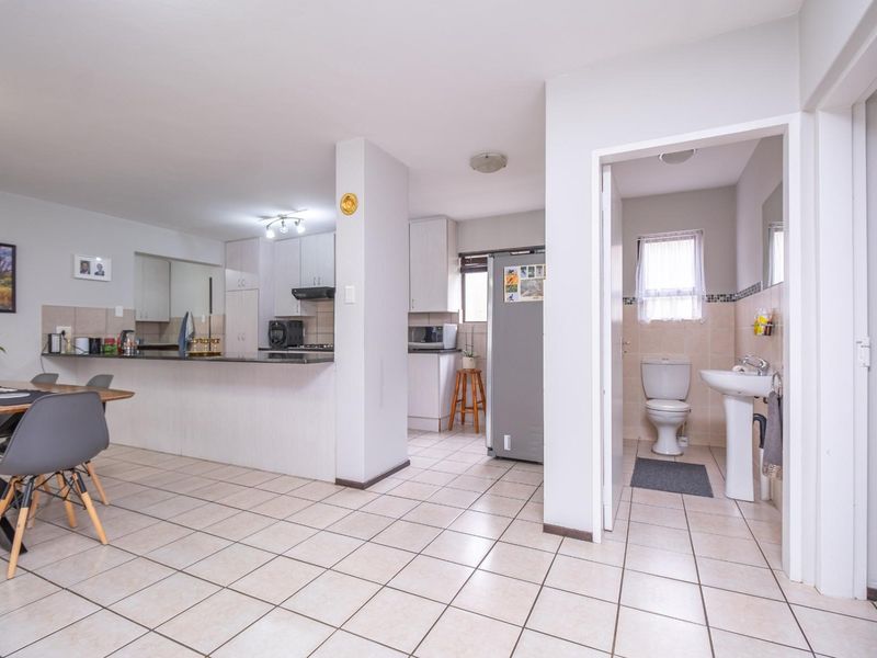 Open plan living area featuring a functional kitchen with granite countertops and an adjacent bathroom with a pedestal sink and toilet.