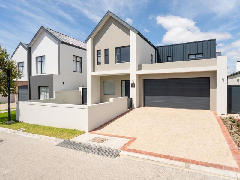 Modern double-story residential home featuring a paved driveway, integrated double garage, and contemporary architectural finishes with clean lines.