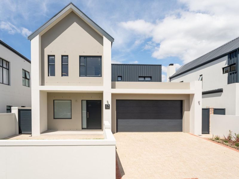 Modern double-story residential home featuring a clean facade, paved driveway, and integrated double garage.