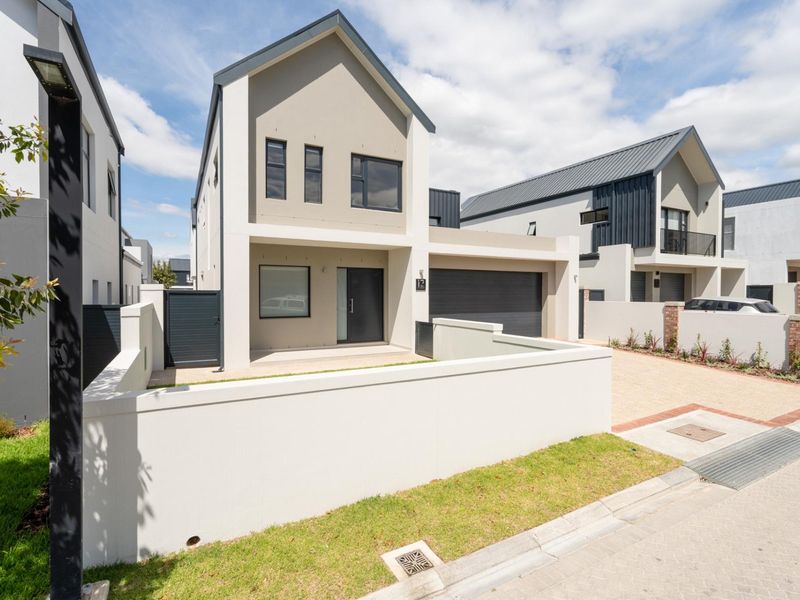 Modern double-storey residential home featuring a contemporary facade, integrated double garage, and secure boundary walling in a well-maintained estate setting.